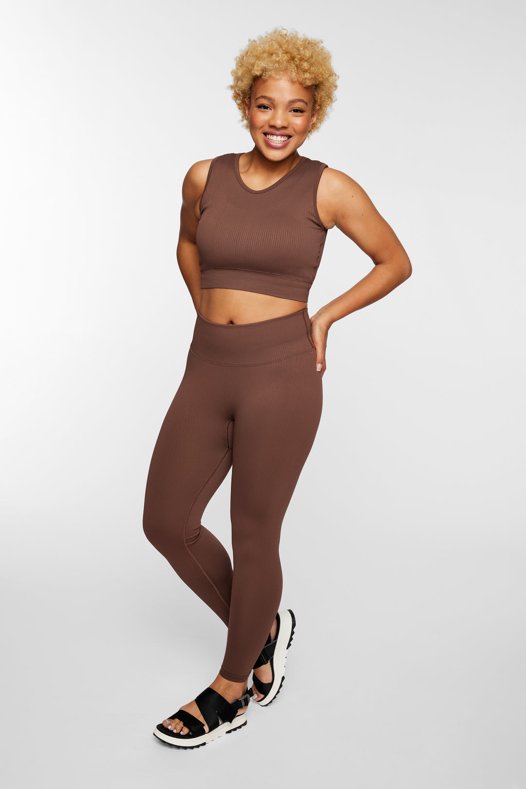 Woman wearing espresso ribbed seamless leggings – front full view, styled with longline sports bra