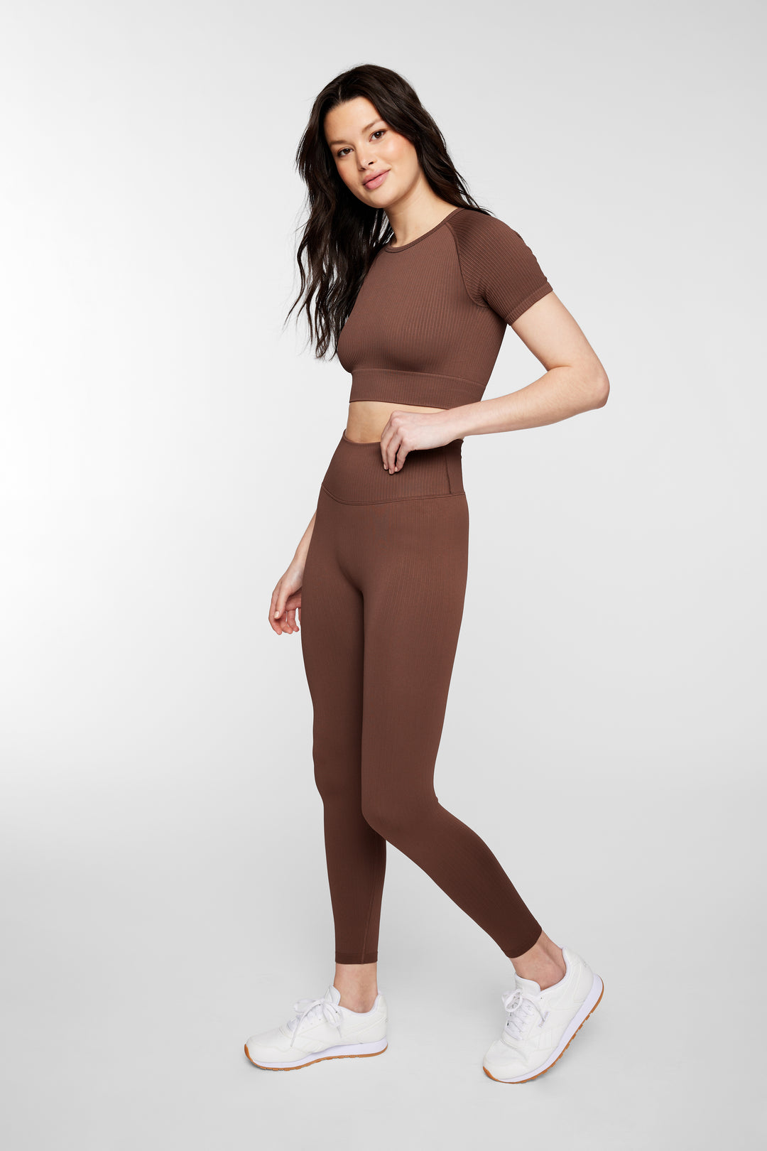 Woman wearing espresso ribbed seamless leggings – front full view, styled with sports bra